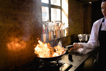 Caucasian chef cooking with fire