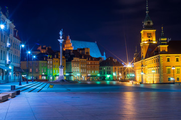 Fototapeta premium Streets of Warsaw Old Town by the night. Zygmunt Column and Royal Castle.