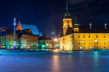 Fototapeta na wymiar Streets of Warsaw Old Town by the night. Zygmunt Column and Royal Castle.