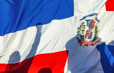 A man with his fist held high in protest with the Dominican flag back