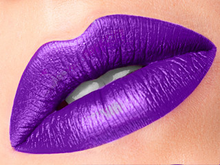 Close up view of beautiful woman lilac lips with matt lipstick. Open mouth with white teeth. Cosmetology, drugstore or fashion makeup concept. Beauty studio shot. Passionate kiss