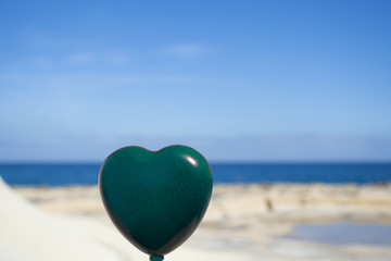 a green heart on the background of the sea. Symbol and concept of love, nature, environment, global earth