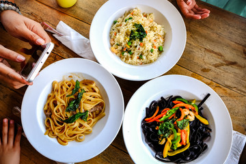 Female Person Taking Picture of Food Served on Restaurant Table Using Smartphone