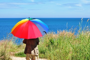 Beautiful women with colorful umbrellas on a hill overlooking the seaside of Koh Samet.