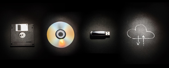Composition on a black background from a floppy disk, a laser disk, a USB flash drive and a cloud...