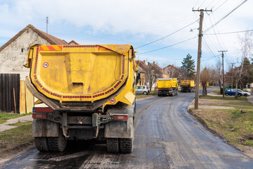 Workers with machines and rollers pave the new road