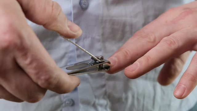 Cutting nails on a man hand with nail tongs. Close up.