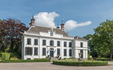 Historic Dutch mansion with trees, blue sky and white clouds