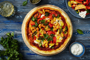 Flat lay of delicious vegan pizza on dark background