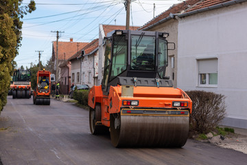 Workers with machines and rollers pave the new road