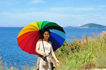 Beautiful women with colorful umbrellas on a hill overlooking the seaside of Koh Samet.