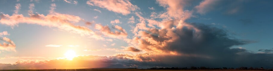 sunset panorama with large clouds on a background of blue sky