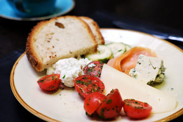 tomatos, cheese. bread, cottage cream on a plate- selective focus background