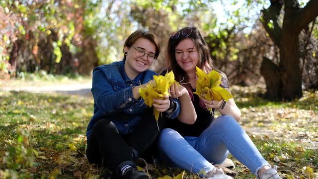 Charming young women kissing gently loving each other stroking touching face skin enjoying romantic tender moments on picnic date in the countryside.