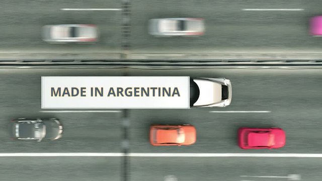 Trailer trucks with MADE IN ARGENTINA text driving along the highway. Argentinean business related loopable 3D animation