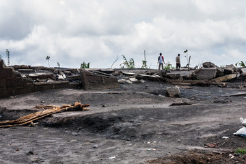 Local people on the ruins of their house after the Mount Merapi eruption, Central Java, Indonesia