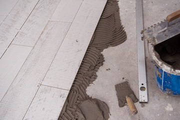 Ceramic wood effect tiles and tools for tiler on the floor