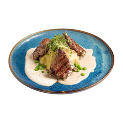 Delicious bbq barbecue spare ribs with mash potato and young green sprouts on a plate, isolated on white.