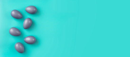 Top view of simple compositon with blue Easter eggs on aqua-mint background