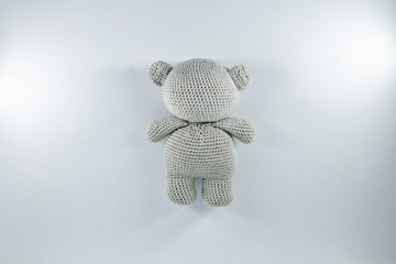 a small knitted toy grey bear cub from the back