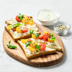 Cherry tomatoes goat cheese sandwiches. Selective focus, copy space.