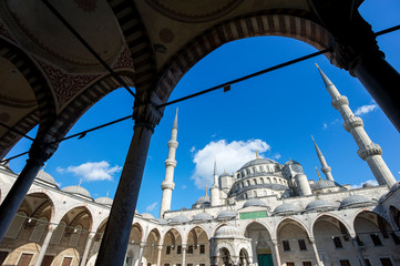 Bright blue sky view of minarets of the Blue Mosque through arch silhouettes in Istanbul, Turkey