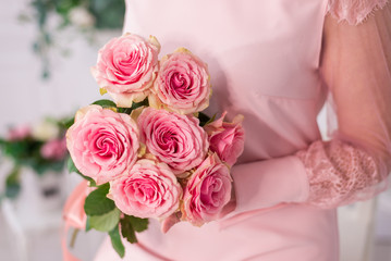 close-up of a bouquet of pink roses in a woman's hands. Greeting gift for mother's day and women's day on March 8.