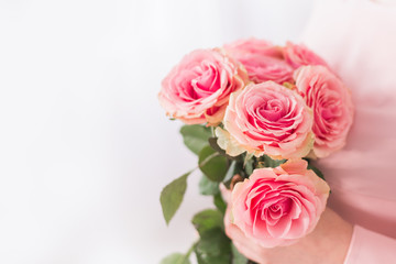 close-up of a bouquet of pink roses in a woman's hands. Greeting gift for mother's day and women's day on March 8.