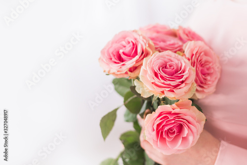 close-up of a bouquet of pink roses in a woman's hands. Greeting gift for mother's day and women's day on March 8.