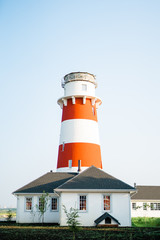 Lighthouse with house on the blue skies background