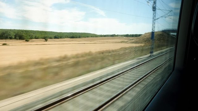 Railroad track. Scenic landscape view from the high speed train driving through suburb of Spain. 4K