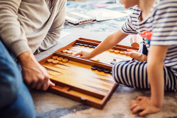 Dad and little son play backgammon - friendly family - leisure with a child
