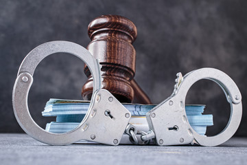 Law gavel with handcuff and banknotes close-up. Bail or corruption concept