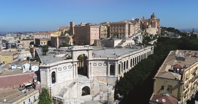 Aerial dolly out shot of the Italian coastal historic city of Cagliari Caralis with roofs, Bastion of Saint Remy, Mediterranean Sea. Traveling holidays vacation. Summertime. Italy, Europe.