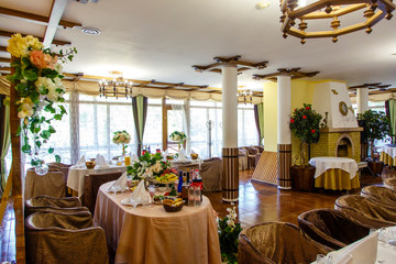 Large restaurant Hall with columns and fireplace. Canned tables. Greek style