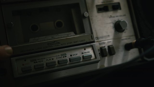 The old cassette player puts a cassette into the boombox, inserts a jack into the headphone jack and presses the record button.