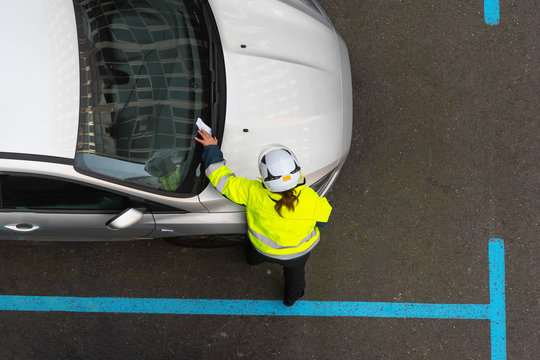 agente de aparcamiento poniendo una multa de estacionamiento
