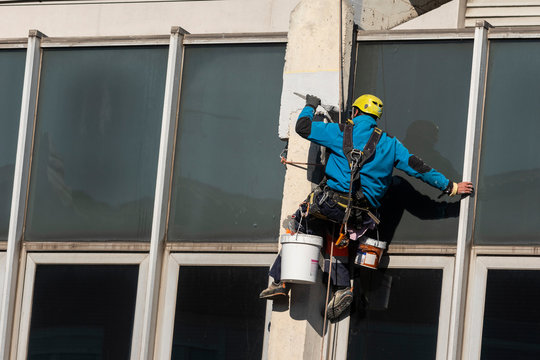 trabajador en altura pintando una fachada de un edificio ó trabajador vertical pintando 