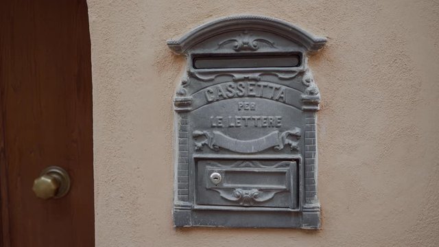 Ancient mail box with text Cassetta per Le Lettere means letterbox on light wall