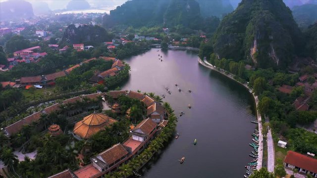 Top down aerial view of rowing boats taking tourists around the sights of Ninh Binh, Northern Vietnam near the small village of Tam Coc. October 2019