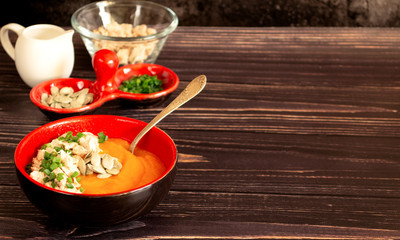 Pumpkin puree soup with spices on a wooden table with copy space. Autumn orange soup.