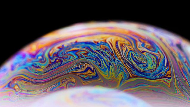 Soap bubble macro rainbow colors creating multicolored patterns. Colorful foam soap bubble slow motion high cinematic quality (Red Dragon Camera). Very similar to other galaxy planets. 