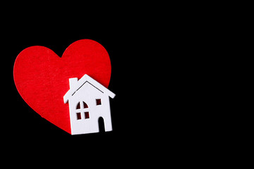 Wooden house with a red heart on a black background