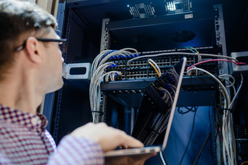 Photo with relfections  in the server room a technician/ It engineer/