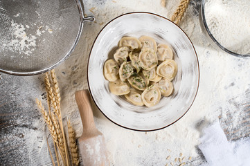 Dumplings with meat. Pelmeni russian national dish. Wheat spikes, on a wooden board