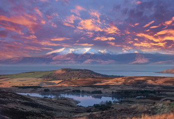 The Magnificent Isle of Arran at Sunset with a Blazing Red Sunset Sky. - obrazy, fototapety, plakaty