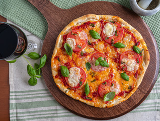 Pizza margherita with bazil on wooden board