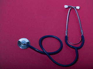 Medical stethoscope or phonendoscope  isolated on red background. Close-up of a stethoscope. flat...