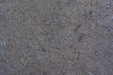 Background texture of old, broken asphalt. Abrasions and cracks on the surface