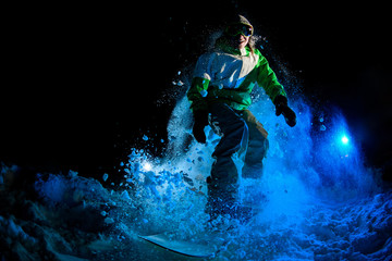Obraz na płótnie Canvas Darkened shot of guy riding on snowboard